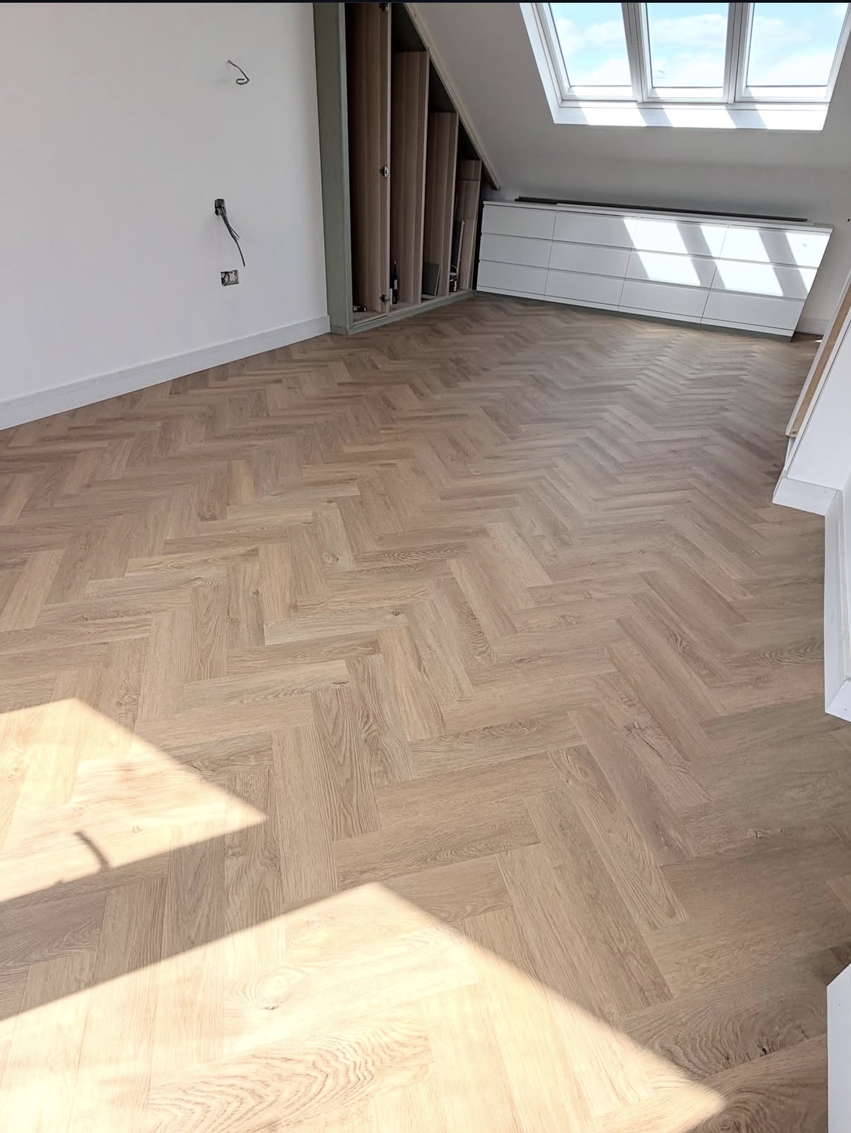 Herringbone flooring installation in a loft room